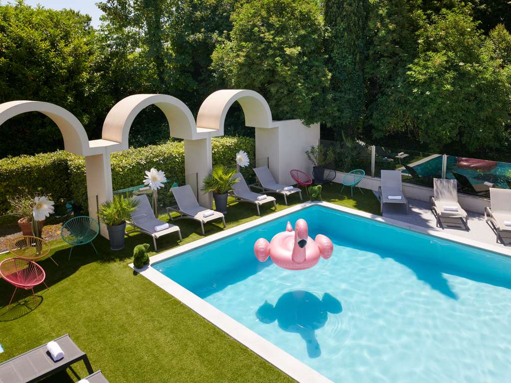 Espace piscine extérieur de l'hôtel, avec transats pour profiter pleinement de votre séjour.