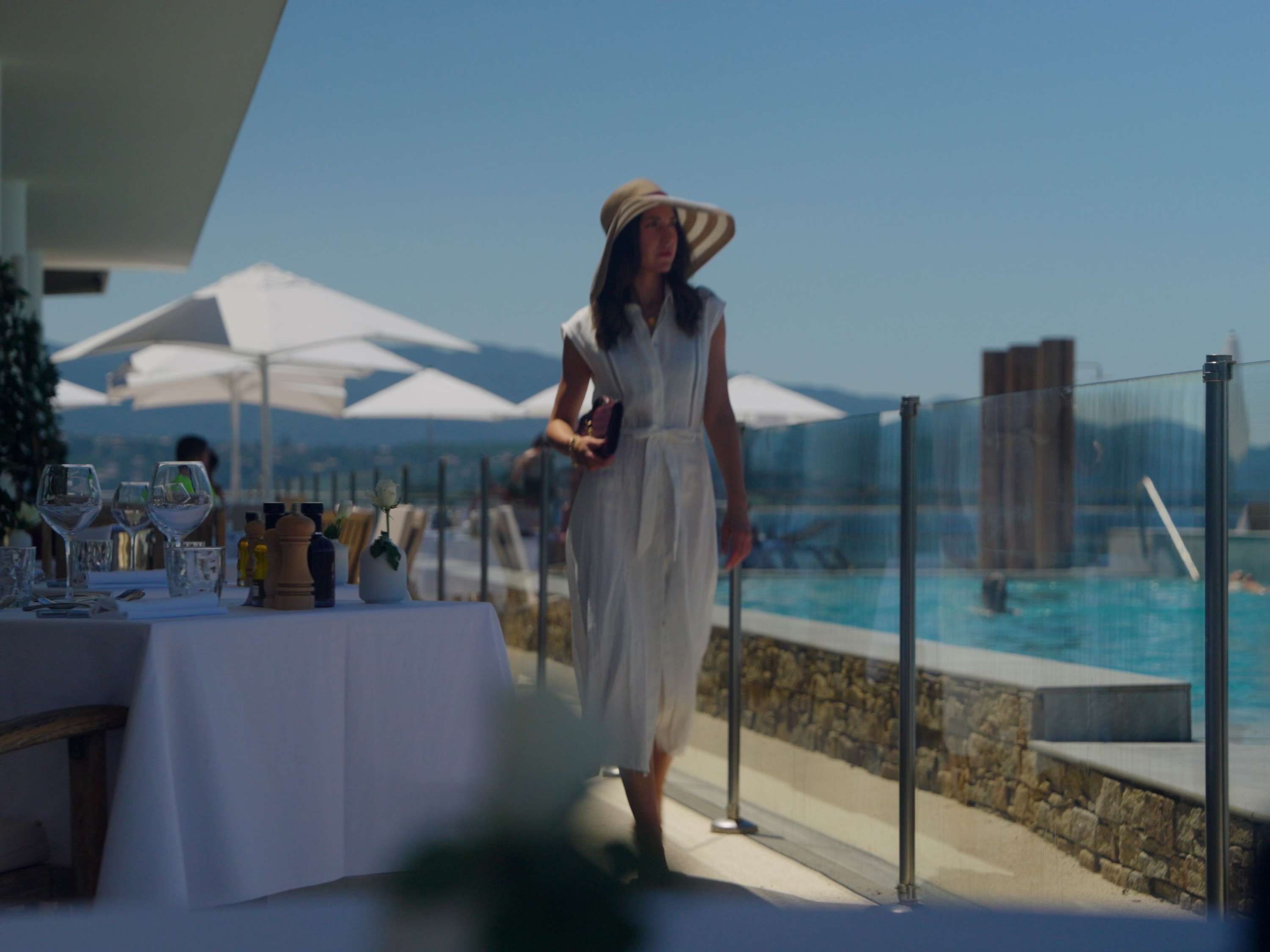 Une cliente profite de la terrasse avec vue sur le golfe d'Ajaccio, entre piscine, mer et soleil, au Sofitel Golfe d'Ajaccio Thalassa Sea & Spa.